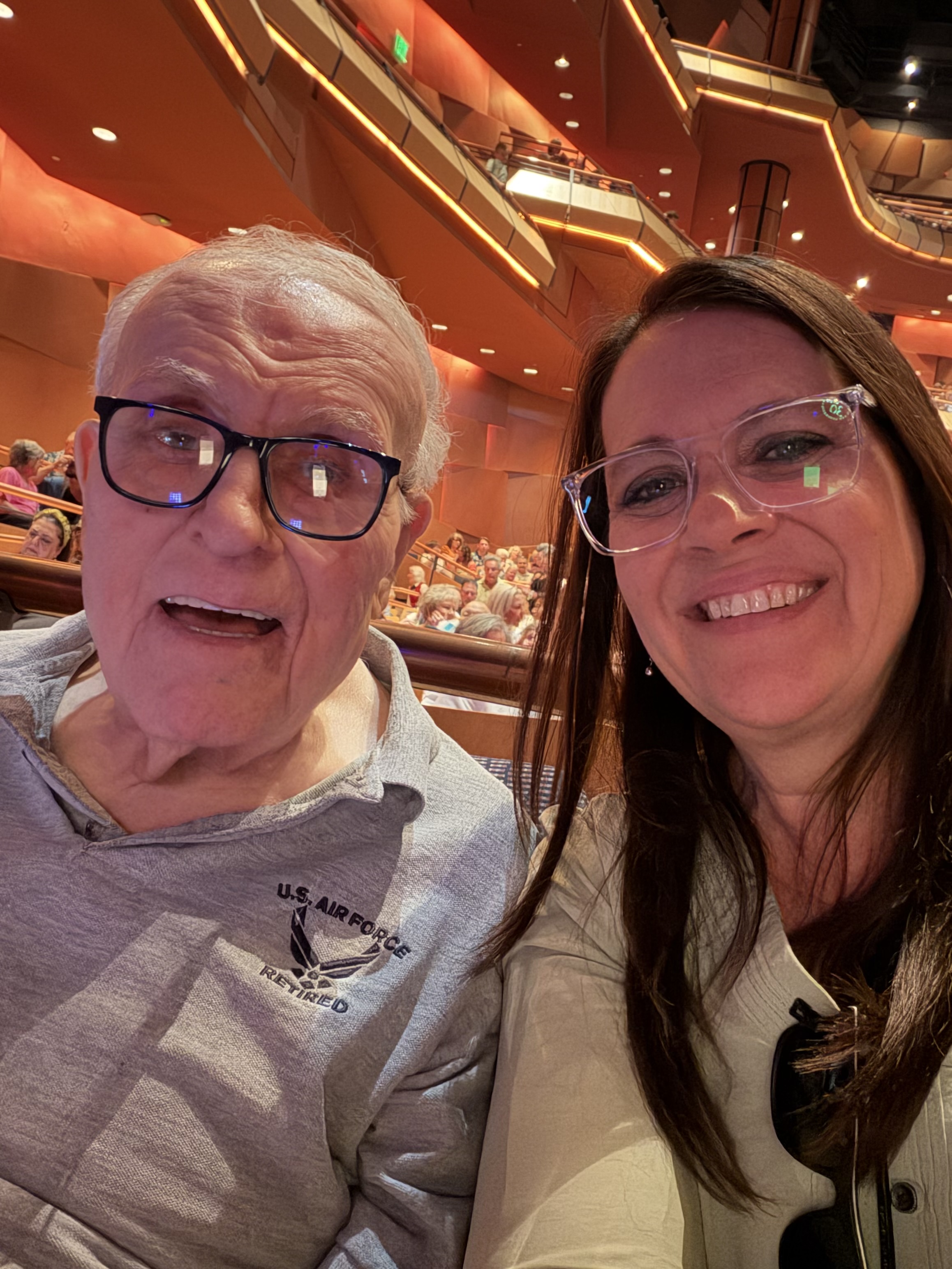 An older man and a woman smiling together at a theater